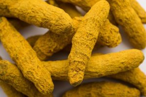 [freepicdownloader.com]-dried-turmeric-roots-sookhi-haldi-as-whole-white-surface-selective-focus-normal
